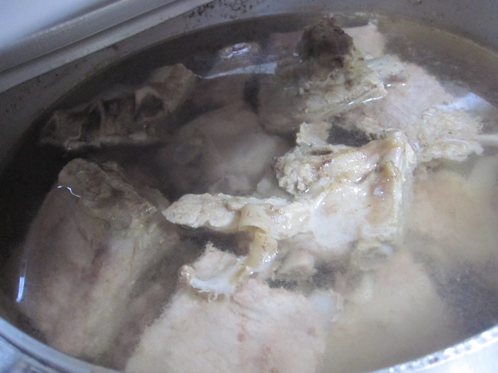 熱湯に浸かる大量の豚肉ソーキ
