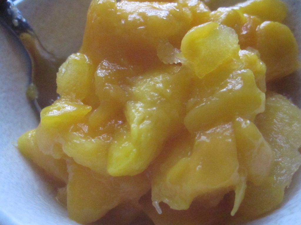 カチカチに凍ったマンゴーをスプーンで削りながら食べるマンゴーアイス