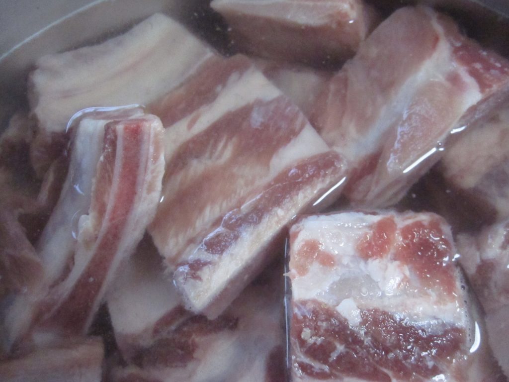 沖縄そばに入れる豚肉を鍋でグツグツ茹でる