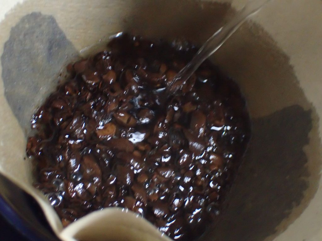 粉々に砕け散った珈琲豆を入れたペーパーフィルターに熱湯を注ぐ