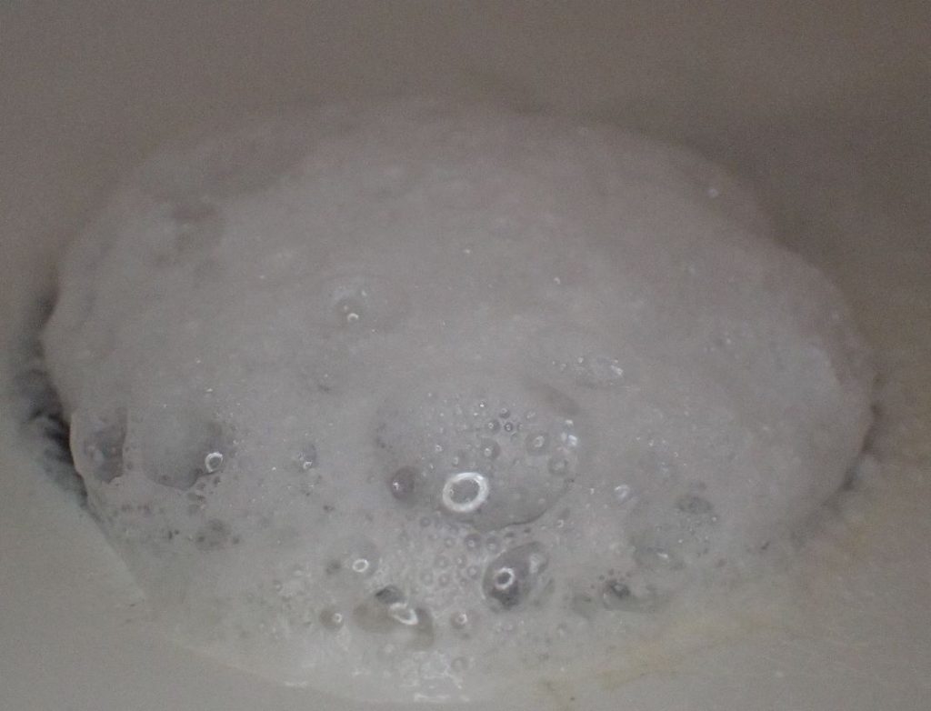 排水口の中から発生した泡が盛り上がる様子
