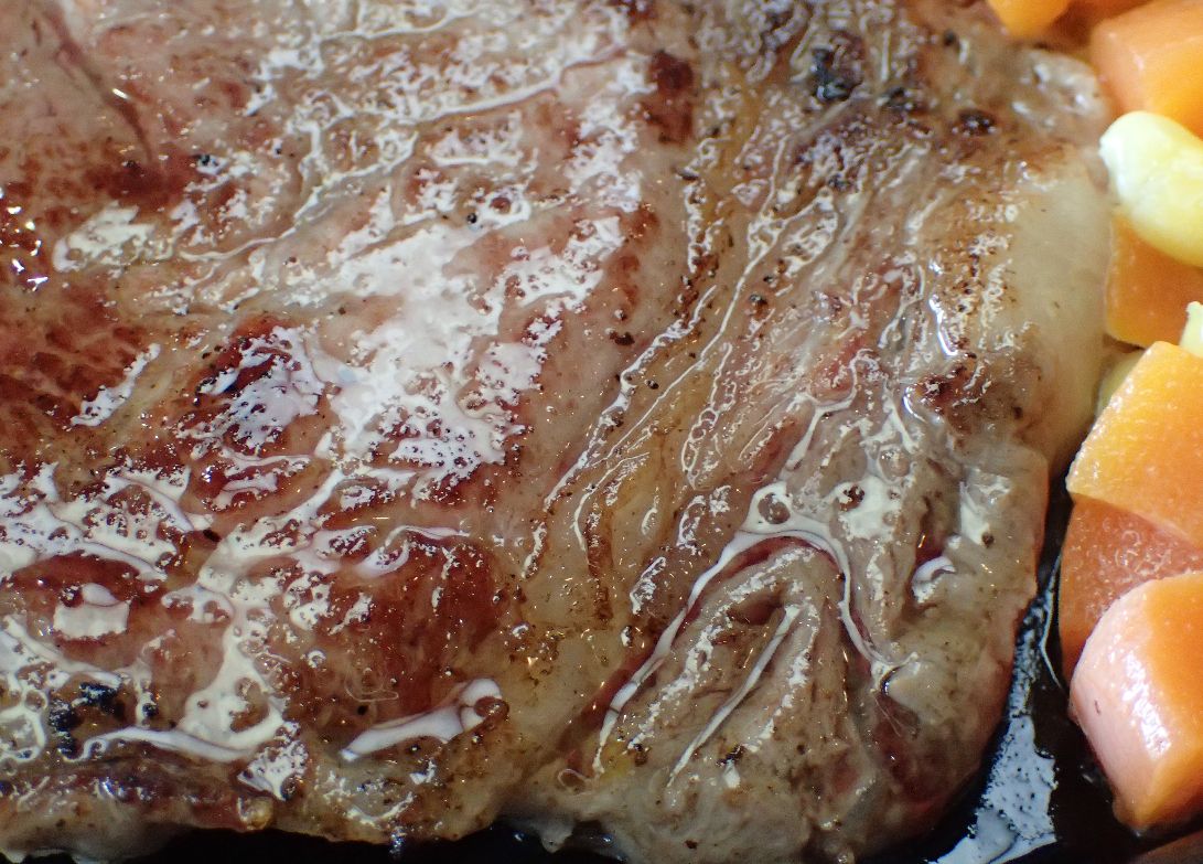 鉄板の上でジュージュー音を立てるステーキ肉！
